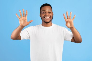 Dokuz Numara. Afrikalı Adam Stüdyoda Mavi Arkaplanda Dokuz Parmak Gösteriyor