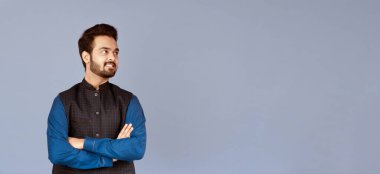 Pozitif Hintli adam kollarını çapraz açmış leylak arkaplan üzerinde duruyor.