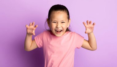 Komik Kaplan. Pençelerini gösteren sevimli Asyalı çocuk portresi, mor stüdyo geçmişi.