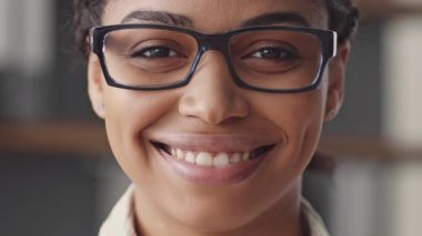 Odaklanmış bir Afro-Amerikalı kadın online bir ders veriyor, bilgisayarından öğrencilerle iletişim kuruyor. Uzak bir öğrenim ortamında modern eğitimi temsil ediyor..