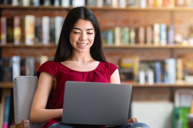 Gülümseyen Koreli kız internette çalışmak ya da kafede okumak için dizüstü bilgisayar kullanıyor, boşluğu kopyala