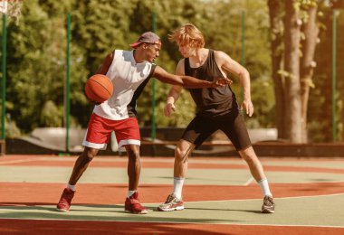 Profesyonel basketbol oyuncuları dostluk maçı sırasında açık alanda.