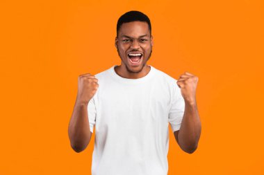 Öyle mi? Duygusal Afrikalı Amerikalı Bağıran Yumruklar Sarı Stüdyo Arkaplanının üzerinde duruyor, Kameraya bakıyor