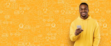 Neşeli bir alıcı, teslimat ve alışveriş ikonlarıyla dolu canlı sarı bir arkaplan karşısında duruyor. Elinde bir akıllı telefon var, bir hizmet için online alımı tamamlamaya hazır..