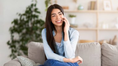 Evde erkek arkadaşıyla cep telefonuyla konuşan gülümseyen Koreli kız hoş sohbetler yapıyor, boş alan arıyor.