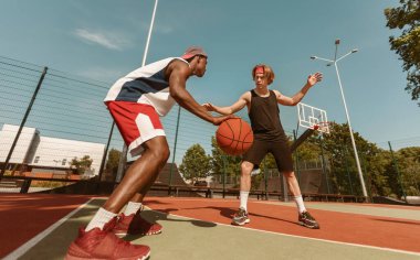 İki genç basketbolcu açık hava sporları sahasında