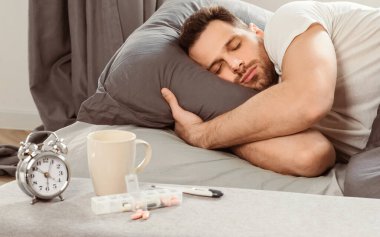 Evde midem bulanıyor. Ateşli bir adam uykusunda kötü hissediyor ve Coronavirus gribi belirtileri yatakta yatıyor. Seçici Odaklanma