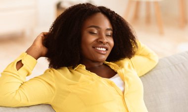 Dinlenme Konsepti. Kapalı gözlerle evde dinlenen siyah kızın portresi. Boş zamanların tadını çıkarıyor.