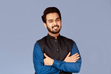 Mor arka planda çapraz kollu pozitif Hintli adamın portresi.