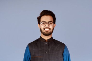 Leylak arka planında şık gözlükler takan gülümseyen Hintli adam.