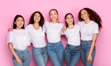 Stüdyoda Pembe Arkaplanda Duran Kameraya Gülümseyen Karışık Gülümseyen Beş Genç Kadın. Kadın Çeşitliliği ve Birliktelik, Güzellik ve Moda Konsepti
