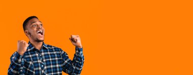 Duygusal Siyah Adam Sarı Arkaplan 'da Stüdyoda Ayakta Duran Yüksek Sesli Yumruklar Haykırıyor. Panorama, Boşluk Boşluğu