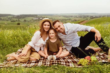 Mutlu Aile Piknikte. Anne ve baba kızlarıyla kırsalda birlikte vakit geçiriyorlar.