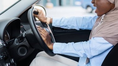 Kızgın siyahi iş kadını, trafiğe takılmış, kaza yapmış, kornaya basmış, kadın şoför birine bağırıyor, trafik sıkışıklığına duygusal tepki veriyor, boş alan arıyor.