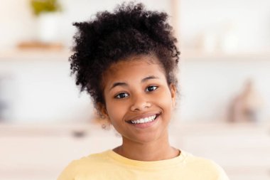 Evdeki koltukta oturmuş kameraya gülümseyen neşeli Afrikalı kız. Genç Portresi