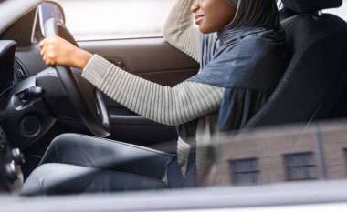 Başı ağrıyan, yorgun, yorgun, Afrikalı Müslüman kadın, başı ağrıyan ya da yorgun, yorgun, direksiyon sallayan, dokunaklı, boş bir manzarası olan siyahi bir kadın.