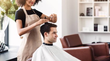 Berber dükkanı yeniden açılıyor. Neşeli adam kuaförlerde yeni saç kesimi yaptırıyor, boş alan.