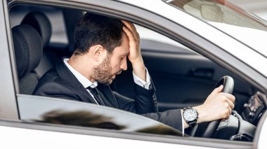 Stresli iş adamı araba kullanıyor, trafiğe takılmış, havaalanına geç kalmış.