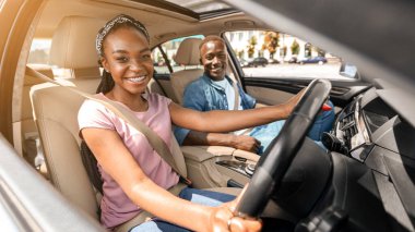 Neşeli genç siyahi aşıklar arabada birlikte oturuyor, araba süren kadın. Mutlu Afro-Amerikan milenyumu. Hafta sonu otomobille seyahat eden kadın ve erkek. Yaz tatilinin tadını çıkarın.