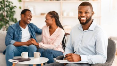 Başarılı bir terapi. Gülümseyen Danışman Ofiste Mutlu Siyah Eşler Arkaplanda, Seçici Odaklanma, Boş Alan