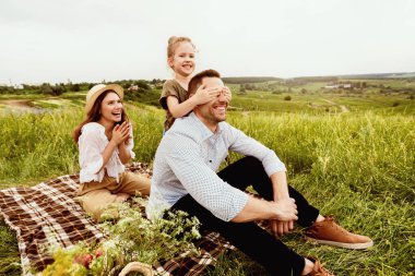 Birlikte vakit geçirmek kavramı. Neşeli kız babasının gözlerini kapatıyor, tahmin et dışarıda kim oynuyor.