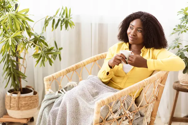 Huzurlu bir sabah. Sakin siyah kız sıcak kahve içiyor, hasır sandalyede battaniyeyle oturuyor ve başka tarafa bakıyor.