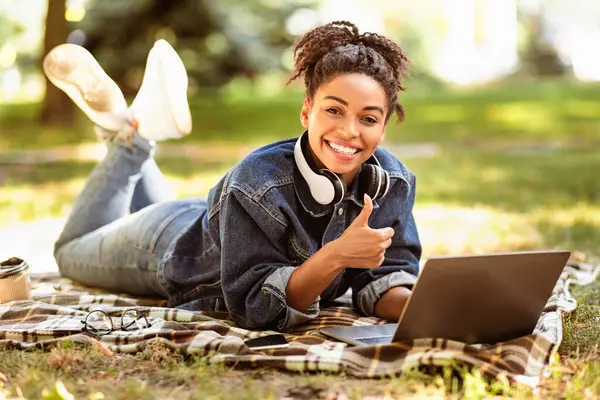 E-öğrenmeyi seviyorum. Siyahi Öğrenci Laptop Kullanıyor Başparmaklarını Parkta Öğreniyor