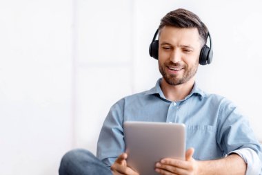 İş yerinde dijital tabletle dinlenen, ofiste oturup film izleyen, müzik dinleyen ya da sosyal ağlara göz atan yakışıklı bir iş adamı.