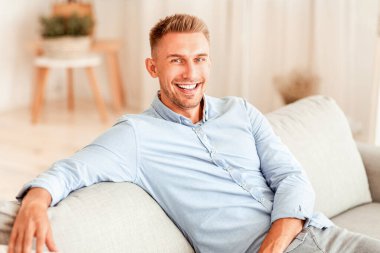 Evde dinleniyorum. Milenyumdan neşeli bir adamın portresi koltuğa yaslanmış, kameraya bakıyor, uzayı kopyalıyor.