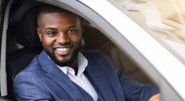 Arabasının camından gülümseyen başarılı siyahi işadamı ofise gidiyor.