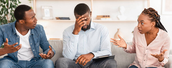 Отчаянный семейный советник, сидящий на диване между спорящей парой в его офисе, уставший от их споров, свободного пространства