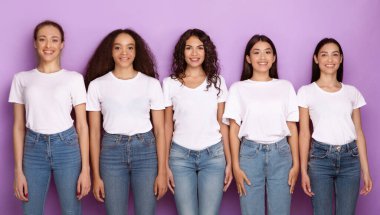 Çok kültürlü genç bayanlar yan yana durmuş Mor Arkaplan 'a bakıp gülümsüyorlar. Milenyum Kadınları Stüdyoda Poz Veriyor. Çeşitlilik ve Birlik Konsepti. Panorama