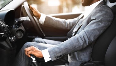 Siyah takım elbiseli adamın arabanın vitesini değiştirmesi, girişimcinin otomobil kullanması.