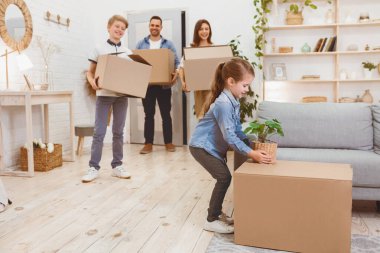 Yeniden yerleştirme. New Flat 'ta taşınan çocuklu aile kutuları boşaltıyor. Boşluğu Kopyala, Seçici Odaklanma