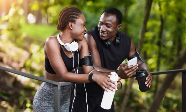 Spor Birlikleri. Spor salonundan sonra dışarıda dinlenen, birbirine sevgiyle bakan, boş alan arayan romantik siyah çift.