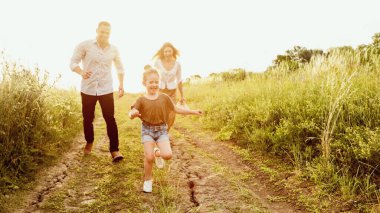 Mutlu ebeveynler ve çocuklar yaz ormanlarında birlikte koşuyorlar, afiş, kopyalama alanı