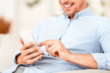 Cep telefonu tutan, ekrana dokunan, kopyalama alanı, bulanık arkaplan