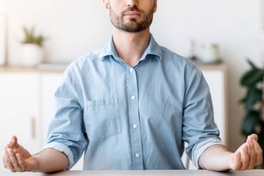 Ofis Zen. Rahatlamış erkek girişimci işyerinde meditasyon yapıyor, işyerinde stresle boğuşuyor, masasında gözleri kapalı oturuyor, boş yer var.
