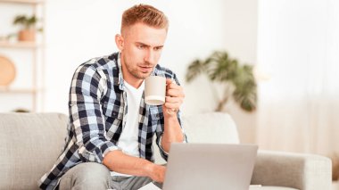 Serbest Kavram. Oturma odasında çalışan odaklanmış bir adamın portresi, koltukta oturan, kişisel bilgisayara bakan. Telesekreter çıkıyor. Klavyede yazan adam, ev ofisinde uzaktan proje yapıyor, boşluğu kopyalıyor