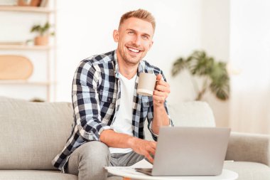 Başarı. Sabahları kahveden zevk alan gülümseyen bir adamın portresi, evdeki oturma odasında dizüstü bilgisayarla çalışan, yukarı bakıp düşünen, mekanı kopyalayan. Mutlu adam rüya görüyor ve elinde çay fincanı tutuyor.