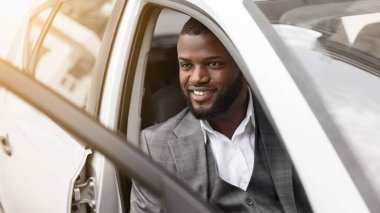 Pahalı takım elbiseli yakışıklı bir iş adamı lüks arabasına biniyor, kapıyı tutuyor ve kameraya gülümsüyor. Afrikalı Amerikalı başarılı girişimci sabah iş görüşmesi için ofise gidiyor.
