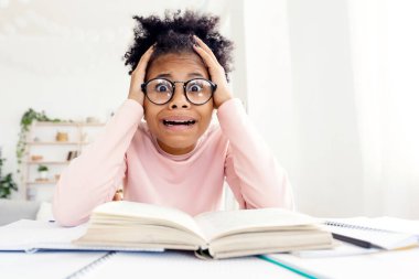 Korkmuş Afrikalı Öğrenci Kız Evde Öğrenen Kameraya bakarak kitap başında ağlıyor. Zor Ödev Kavramı