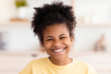 Evdeki koltukta oturup gülen pozitif siyah kız. LOL, Good Espri, Espri anlayışı