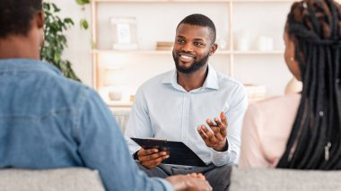 Çift Terapisi seansı. Siyahi karı ve kocayla ofisinde görüşen, genç eşlere tavsiye veren, evli Afrikalı çiftler el ele tutuşan ve seçici danışman,