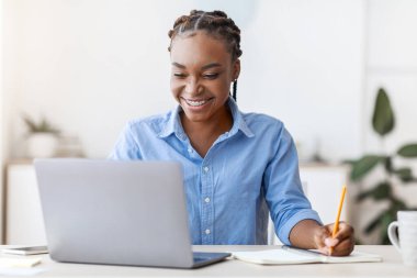 Çevrimiçi Eğitim. Evde dizüstü bilgisayar kullanan ve not alan, uzaktan öğrenmenin keyfini çıkaran, internetten Webinar 'ı izleyen, Uzay Kopyalayan,