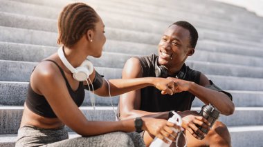 İyi iş ortağı. Siyah atlet Guy ve kız yumruğu dışarıda antrenman yaptıktan sonra, şehir basamaklarında otururken, parkta antrenman yaptıktan sonra dinlenirken,