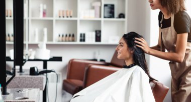 Değişiklik arayan genç bir kadın, güzellik salonunda yeni bir saç stili deniyor, boş bir alan.