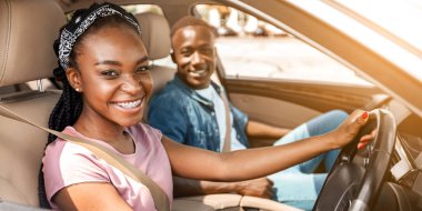 Beyaz arabada oturan, hafta sonları gezen, kameraya neşeyle gülümseyen, araba penceresinden yan gören Afrikalı Amerikalı çiftin portresi. Yaz tatili, yolculuk, gezi konsepti