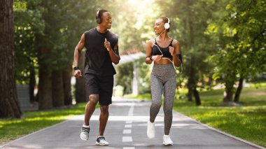 Çift Faaliyetleri Konsepti. Mutlu Afro-Amerikan Koşucuları Park 'ın dışında birlikte koşuyor, fotokopi uzayı ile tam boy