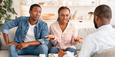 Mutsuz siyah çift, evlilik danışmanıyla görüşüyor, ilişki sorunları tartışıyor, terapi odasındaki koltukta oturan kızgın Afrikalı genç eşler profesyonel yardıma ihtiyaç duyuyorlar.